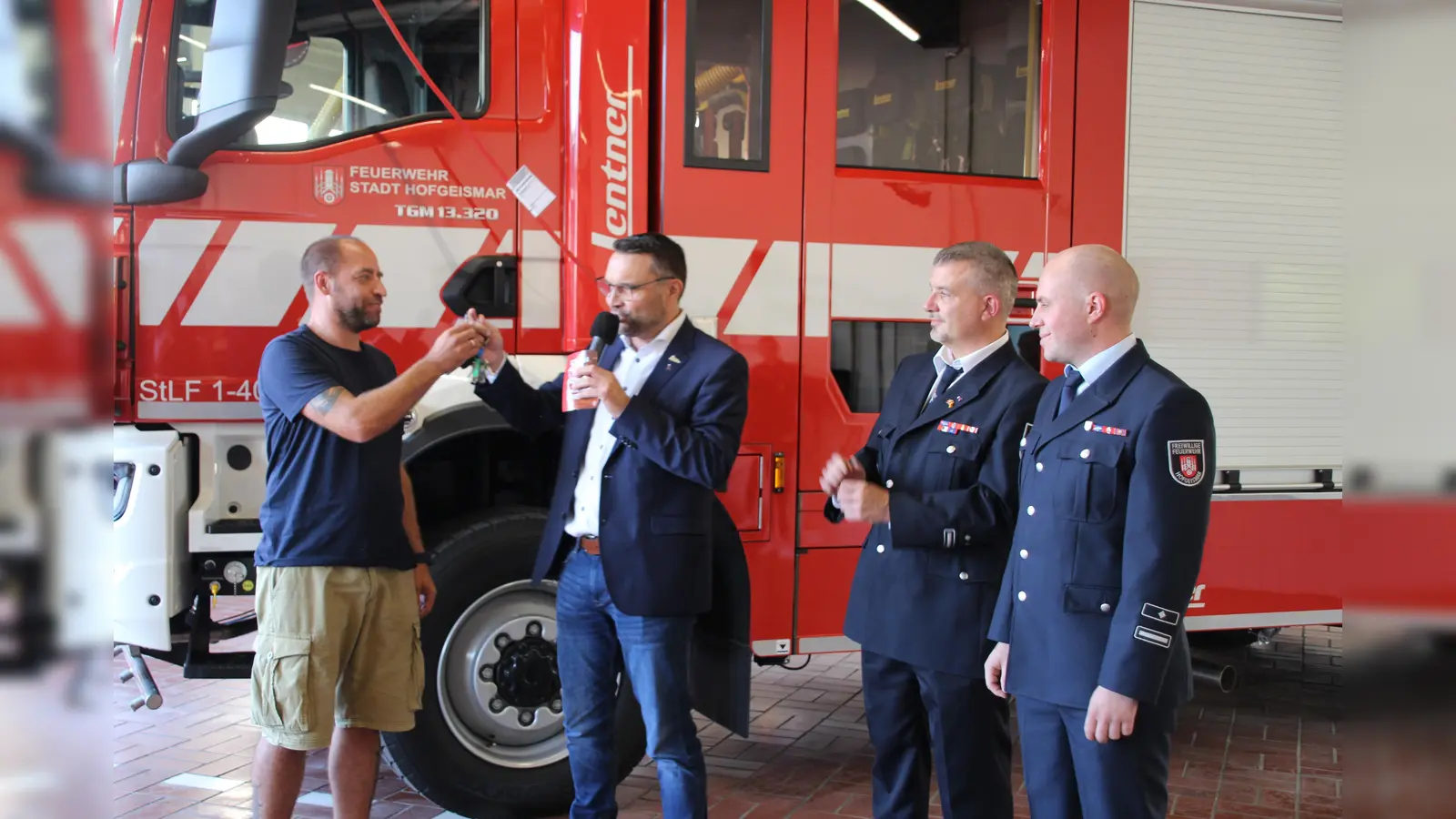 Symbolische Schlüsselübergabe: Sven Lang (l.) nimmt stellvertretend den Schlüssel für das neue Fahrzeug von Bürgermeister Torben Busse entgegen, daneben (2.v. rechts) Tobias Sommer, stellv. Stadtbrandinspektor, und Wehrführer Maximillian Wiegand. (Foto: Julia Sürder)